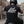 Person wearing a black 'Grit Avenue' t-shirt on a motorcycle in an urban setting.